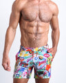 Front view of model wearing the PEOPLE FROM IBIZA men’s beach tailored shorts featuring color pop art by the Bang! Clothes brand of men's beachwear from Miami.