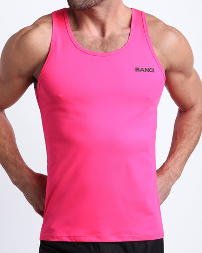 Frontal view of male model wearing the PINK BOMB in a hot pink gym tank top for men by the Bang! brand of men's beachwear from Miami.
