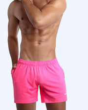 Side view of men’s performance exercise shorts in a bright pink color made by BANG! Clothing the official brand of mens sportswear.