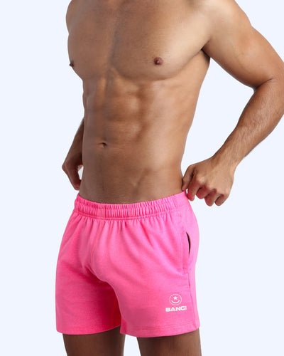 Frontal view of male model wearing the PINKTENSITY jogger shorts in a solid pink quick-dry by the Bang! brand of men's beachwear from Miami.