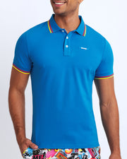 Front view of a sexy male model wearing a premium 100% Cotton Pique Polo Shirt for men from BANG! Brand in a blue color.