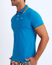 Side view of a male model wearing a slim fit sexy collared shirt for men from BANG! Miami in sky blue color. 