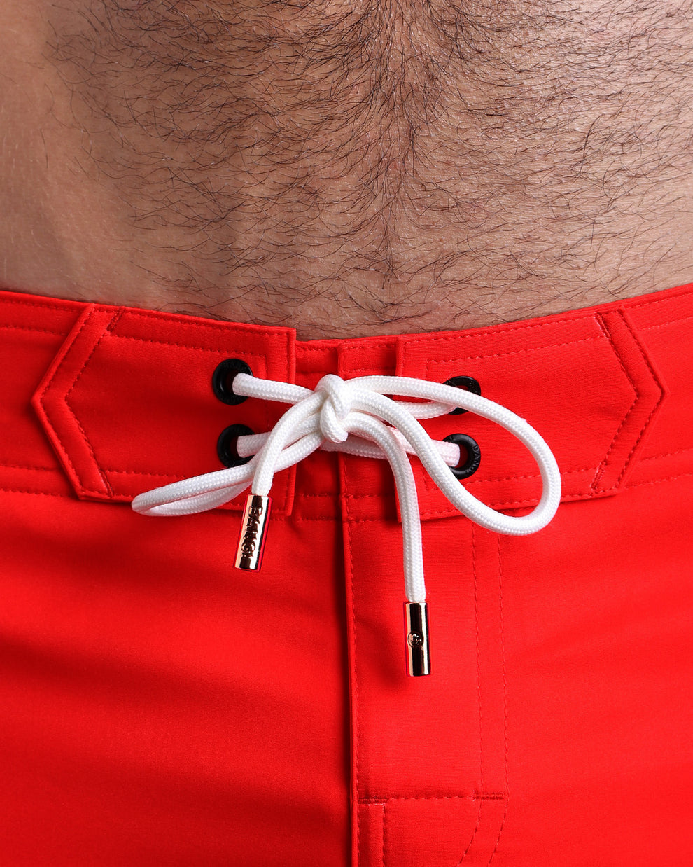 Close-up view of inseam and details of these shorts for men, with white cord and custom branded golden cord-ends, and matching custom eyelet trims in gold.