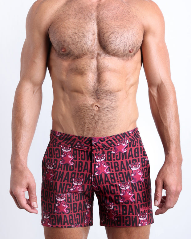 Front view of model wearing the STARSTRUCK men’s beach tailored shorts in a red berry color with black BANG! Typography print and tiger pop art by the Bang! Clothes brand of men&
