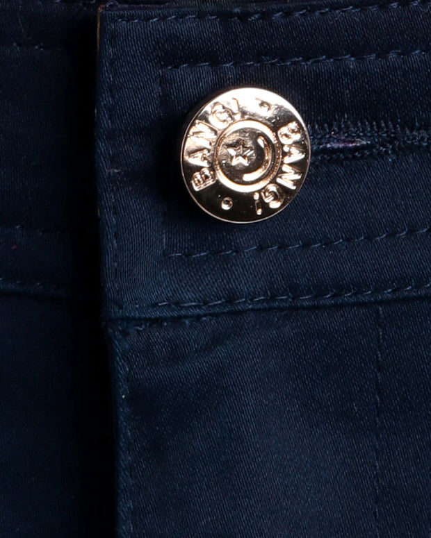 Close up view of cotton fabric chino street shorts with custom engraved front tack button in golden finish by BANG! men&