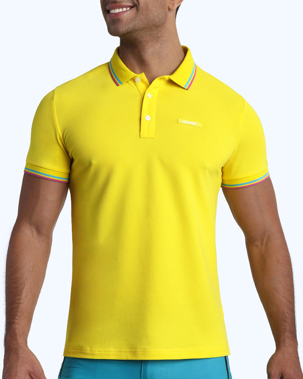 Front view of a sexy male model wearing a premium 100% Cotton Pique Polo Shirt for men from BANG! Brand in a bold yellow color.