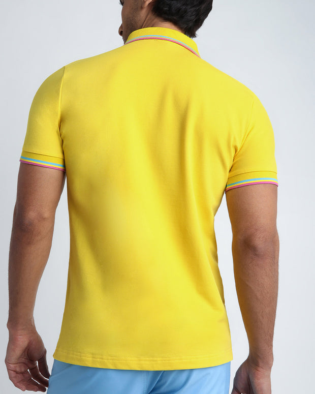 Back view of a sexy model wearing a short-sleeve classic polo shirt for men in a bright yellow color from BANG! Clothing the official brand for menswear.