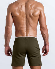 Back view of the men's above-knees length fitness workout shorts in a solid dark green color by BANG! menswear Miami.