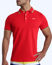 Front view of a sexy male model wearing a premium 100% Cotton Pique Polo Shirt for men from BANG! Brand in a bold red color.