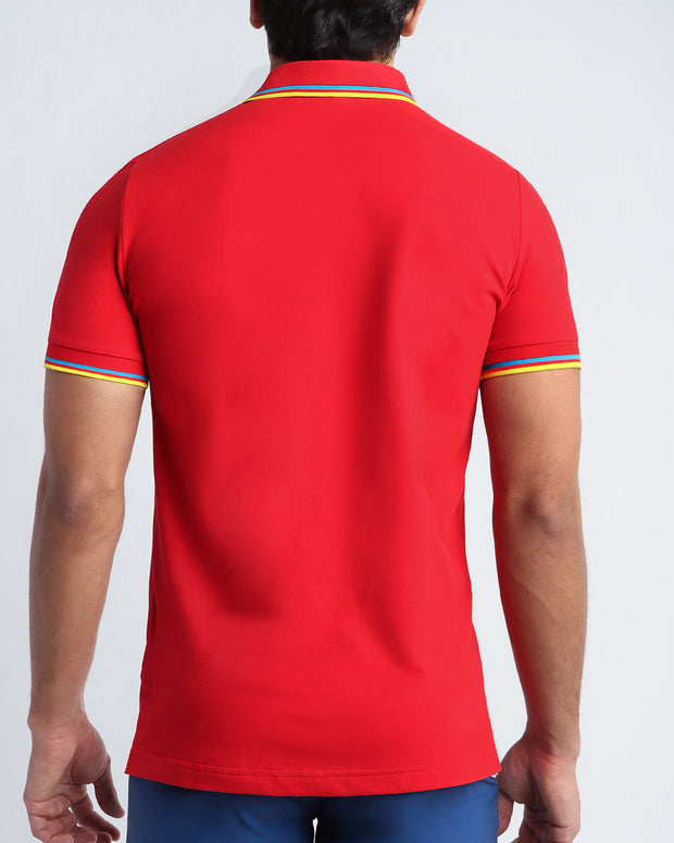 Back view of a sexy model wearing a short-sleeve classic polo shirt for men in a bright red color from BANG! Clothing the official brand for menswear.