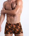 Frontal view of model wearing the TIGER HEARTS men’s square leg swim trunks featuring Brown with Orange Tigers pop art by the Bang! brand of men's beachwear from Miami.