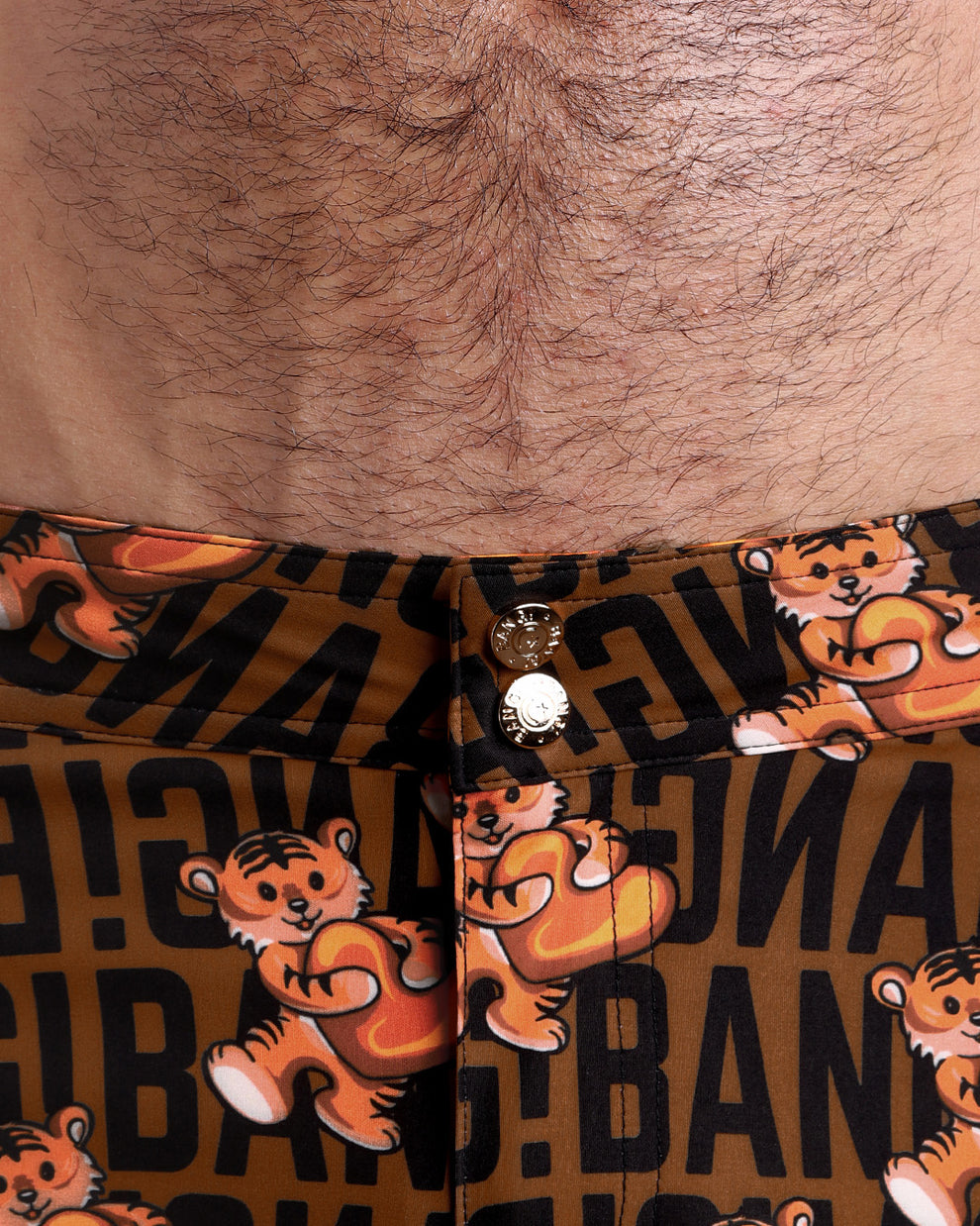 Close-up view of men’s summer beach shorts by BANG! clothing brand, showing custom branded golden buttons.