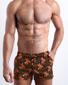 Front view of model wearing the TIGER HEARTS men’s beach shorts featuring Brown with Orange Tigers pop art by the Bang! Clothes brand of men's beachwear from Miami.