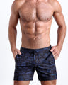 Front view of model wearing the TOILE DE MIAMI (BLACK/BLUE)  men’s beach tailored shorts with Toile De Jouy in black with dark navy blue Art by the Bang! Clothes brand of men's beachwear from Miami.