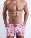 Front view of model wearing the TOILE DE MIAMI (RED) men’s beach shorts in white with red blue Toile De Jouy art by the Bang! Clothes brand of men's beachwear from Miami.