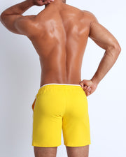 Back view of the men's above-knees length fitness workout shorts in a solid bright yellow color by BANG! menswear Miami.