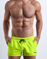 Frontal view of a sexy male model wearing ULTRA NEON men’s swimsuit in bright lime green color by the Bang! Menswear brand from Miami.