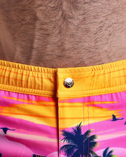 Close-up view of the UNDER A NEON SKY men’s beach shorts, showing custom branded metal button in gold by Bang!