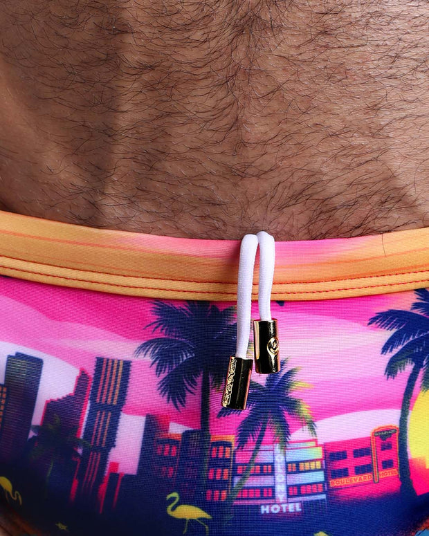 Close-up view of the UNDER A NEON SKY men’s drawstring briefs showing white cord with custom branded golden cord ends, and matching custom eyelet trims in gold.