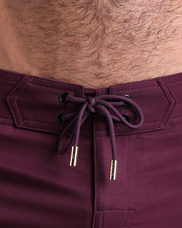 Close-up view of inseam and details of these shorts for men, with dark red cord and custom branded golden cord-ends, and matching custom eyelet trims in gold.