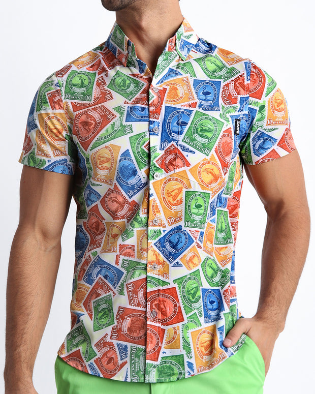 Front view of the VIA POSTAL men’s  short-sleeve hawaiian stretch shirt in white with colorful Miami pop art postage stamps designed by the Bang! brand of men&