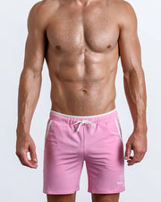 Frontal view of male model wearing the VITAL PINK athletic crossfit gym shorts in a solid baby pink color by the Bang! brand of men's beachwear from Miami.