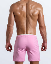 Back view of the men's above-knees length fitness workout shorts in a solid light pink color by BANG! menswear Miami.