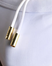Close-up view of men’s summer swimwear by BANG! clothing brand, showing white cord with custom branded golden cord ends, and matching custom eyelet trims in gold.