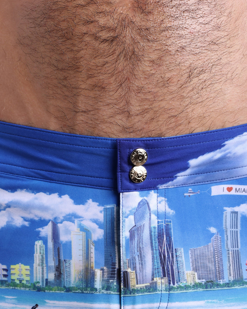 Close-up view of men’s summer beach shorts by BANG! clothing brand, showing custom branded golden buttons.