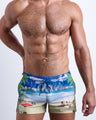 Front view of model wearing the WISH YOU WERE HERE men’s beach shorts Miami Beach skyline art by the Bang! Clothes brand of men's beachwear from Miami.