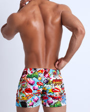 Back view of a sexy male model wearing YEAH-YEAH men's swimwear with pop-culture theme made by the Bang! brand of men's beachwear.