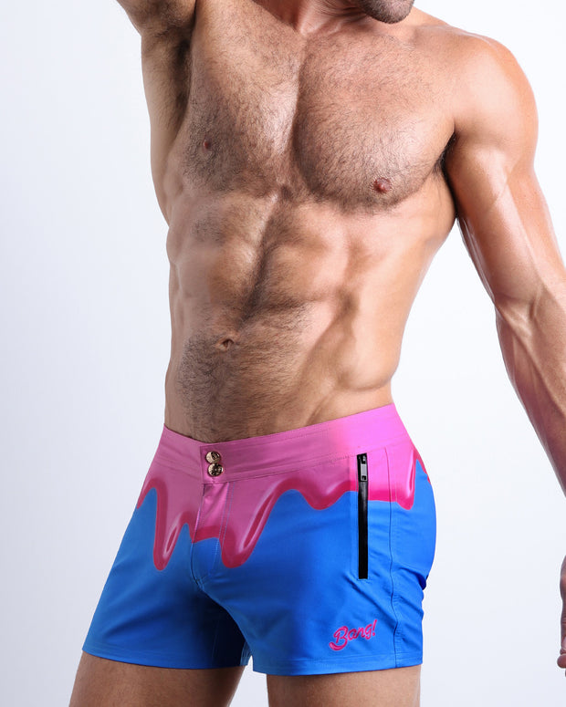 Left side view of men’s Summer swimsuit in YOU MELT ME featuring magenta pink melting ice cream print made by Miami based Bang brand of men&