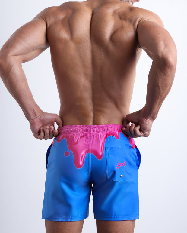 Back side of the YOU MELT ME beach mens swimsuit in bright blue and hot pink with back pocket with BANG! Logo.