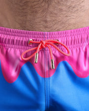 Close-up view of the YOU MELT ME men’s summer shorts, showing blue cord with custom branded golden cord ends, and matching custom eyelet trims in gold.